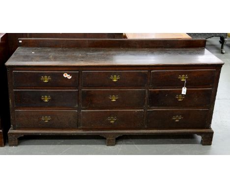 A GEORGE III OAK DRESSER ON BRACKET FEET, WITH NINE MOULDED DRAWERS, 94CM H; 198 X 52CM Handles replaced. Scuffed and rubbed 