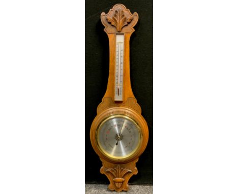 A German Carved oak aneroid barometer, and thermometer, 90cm high. 