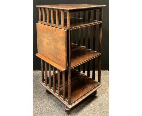 An early 20th century revolving oak bookcase, rectangular top with carved gadroon edge, three tiers of shelving with drop dow