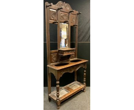 A Late Victorian oak hall stand, carved cresting and panels to top, central bevelled mirror with lidded glove-box below, the 