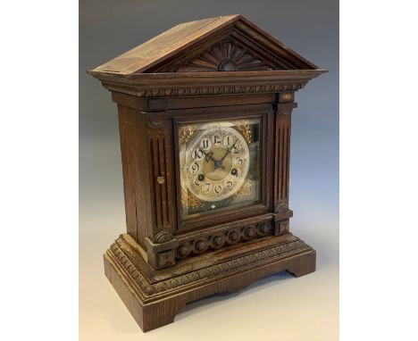 An early 20th century Junghans mantle clock, eight-day movement, oak case, architectural pediment, glazed door, brass and sil