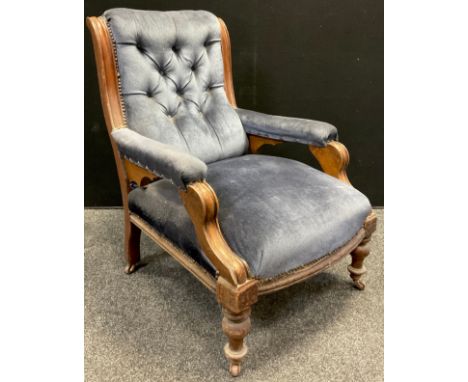 A Victorian walnut fireside armchair, button-back, sprung seat, turned legs, ceramic casters, 87.5cm high x 62cm wide x 72cm 