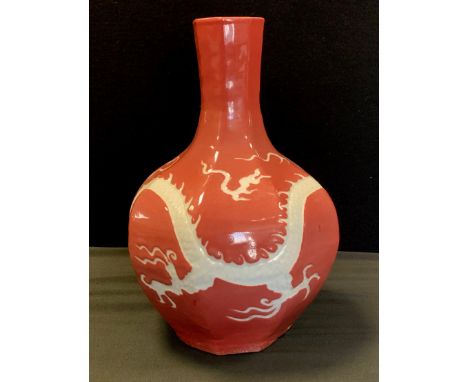 A Chinese octagonal baluster bottle vase, incised with a Dragon and the Pearl of Wisdom, pink ground, 31cm high. 