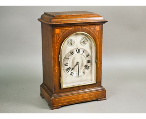 A German oak inlaid mantel clock with twin-train eight day movement striking on gongs c/w pendulum and key, 35 cm high 