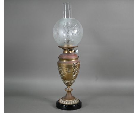 A copper and brass oil lamp with etched glass shade