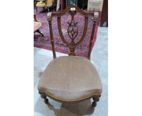 A Victorian walnut nursing chair with carved opernwork splat, on fluted tapered legs with ceramic castors