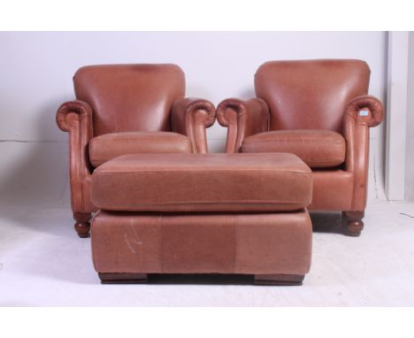 2 Thomas Lloyd brown leather chesterfield armchairs having turned stub mahogany feet with shaped arms and elbow rests togethe