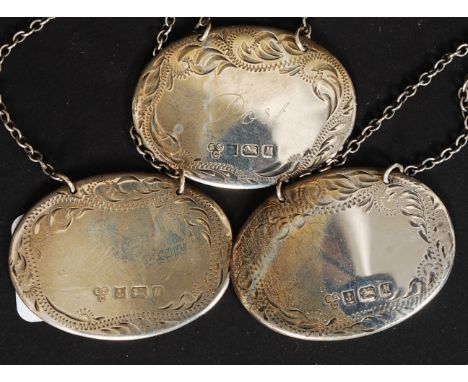 A collection of three hallmarked silver decanter / bottle lables, each hallmarked, complete with hanging chains.