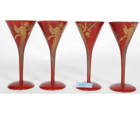 A group of four red laquered and gilt Chinese wine glasses having bird of paradise and foliate design