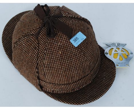 A vintage motorcycle helmet having tweed deerstalker covering together with a vintage AA motoring badge
