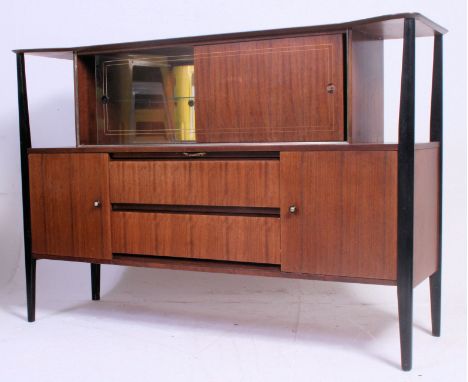 A vintage 1950's retro teak cocktail display cabinet having shaped ebonised columns with mirror lined cabinet over sideboard 