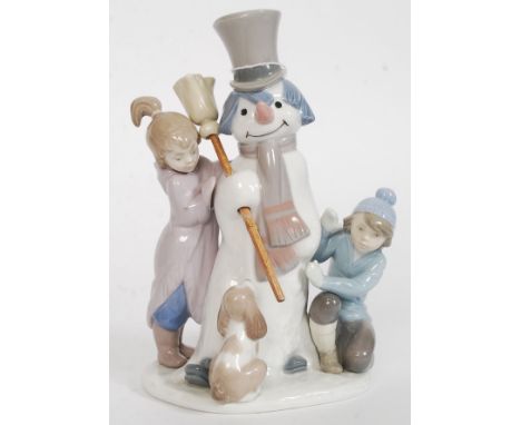 A Lladro figurine ' The Snowman ' model number 5713, modelled as two children and a puppy around a snowman, printed factory m