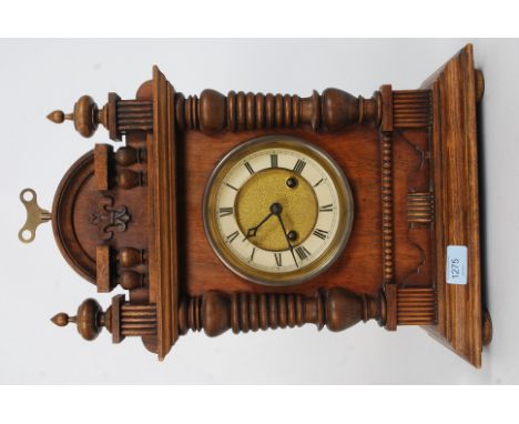 An early 20th century oak cased eight day mantle clock, glazed door, gilt circular face, Roman numerals, flanked by baluster 