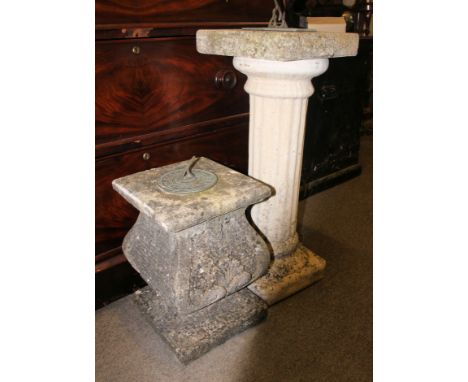 A stone sundial raised on a column plinth together with another stone sundial of lower squat form - garden ornaments