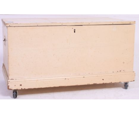 A vintage 20th century  pine painted / shabby chic trunk on later casters having hinged top