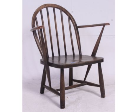 A vintage Low Ercol style childs armchair having saddle seat with arched back and shaped elbow rests