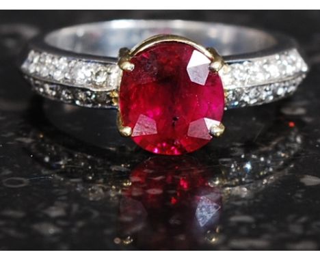 A stunning ladies 18ct white gold ruby and diamond ring. The 1.7ct cushion cut ruby being flanked by 20 diamonds. White gold 