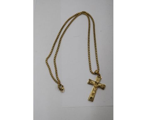 A YELLOW METAL CRUCIFIX ON A CHAIN