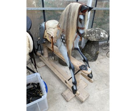 A VINTAGE CHILDS ROCKING HORSE ON WOODEN BASE