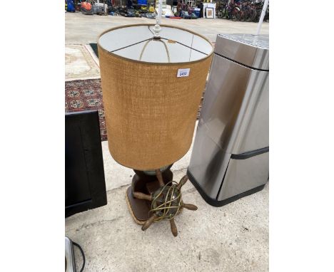 A DECORATIVE WOODEN TABLE LAMP WITH SHIPS WHEEL AND BAROMETER BASE