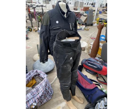 THE BOTTOM HALF OF A MANEQUIN WITH MOTORBIKE LEATHERS AND A MANEQUIN WITH A MOTORBIKE JACKET