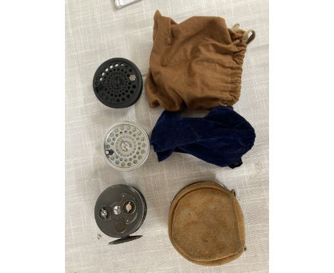 A FLY FISHING REEL WITH A CARRY POUCH AND TWO REEL SPOOLS WITH CARRY BAGS