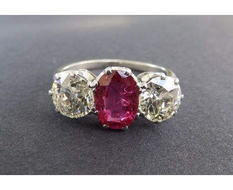 A certified Burmese ruby &amp; diamond three stone ring, the oval claw set ruby weighing approximately 1.65 carats, flanked b