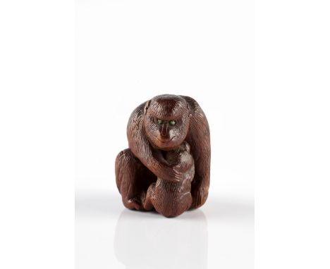 A Japanese wood netsuke late Meiji of a squatting monkey nursing her young, 5cm high