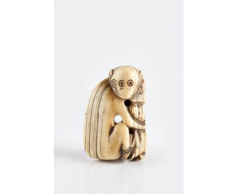 A Japanese ivory Netsuke Edo Period (1603-1868) carved depicting a monkey clutching a dog, 4.5cm high