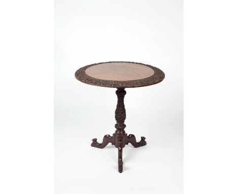 An Anglo-Indian carved tripod table 19th century the top and legs caved with scrolling foliate patterns and feet finished wit