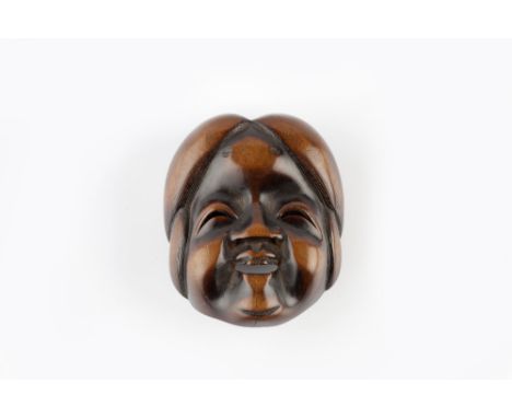 A wood Kyogen netsuke mask of Okame (Oto) 19th Century signed Gyokuju, the smiling face framed by her hair style and having a