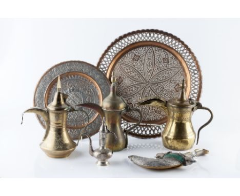 A collection of Middle Eastern metal ware including a silver metal dagger, two brass and copper dishes, and four ewers, each 