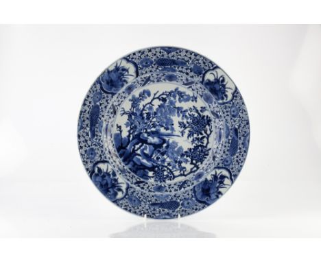 A Chinese blue and white charger Kangxi (1662-1722) decorated with rockwork, peonies and pheasants within a panelled border, 