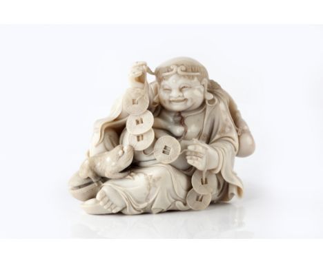 A Chinese soapstone carving of a smiling Sennin Gama  19th/20th Century with hat and gourd, holding a string of cash at his f