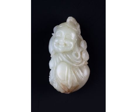 A Chinese white and rust tinted jade pebble 18th Century carved as a reclining figure of Lie tei holding a string of coins, h