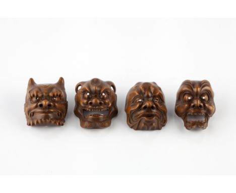 A group of four boxwood netsuke masks Meiji period Oni with accentuated eyebrows and beard, another with down-turned horns an