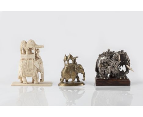 An Indian caved wooden and ivory elephant  decorated with metal armour inset with gems and bone tusks, 9cm high, together wit