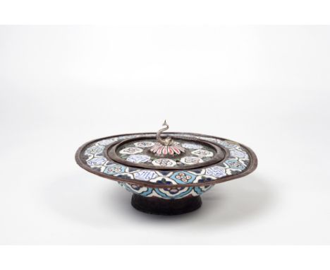 A Syrian brass lidded basin  with blue, red and white enamel within an embossed pattern of medallions finished with hand pain
