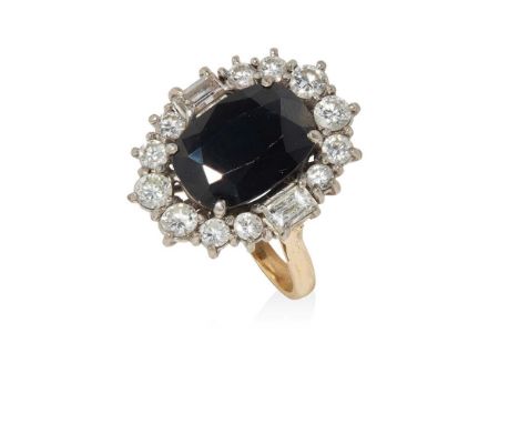 claw set with an oval-cut sapphire, in a border of round brilliant and baguette-cut diamonds, to a plain shankRing size: M