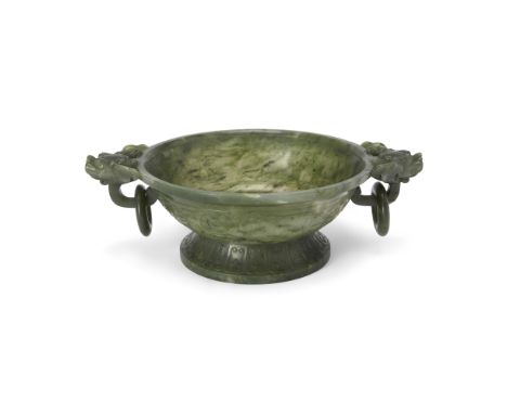A Chinese spinach jade twin-handled bowlQing dynasty, 18th centuryStanding on a splayed foot decorated with a band of lotus p