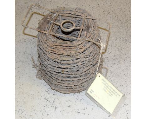 A roll of WW2 Barbed Wire with carry handles. Having a museum label from the Whitehall Theatre of War