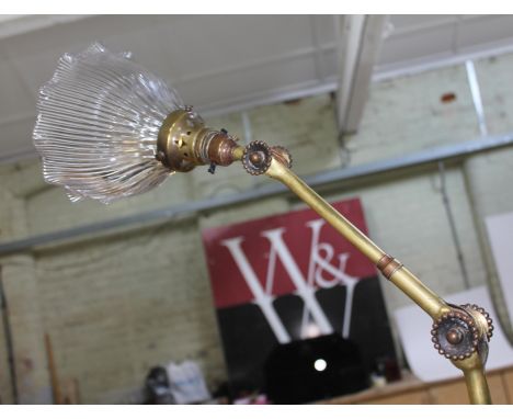 An early 20th century adjustable brass angle lamp by Dugdill, with pressed glass shade, two joints and brass column with two 