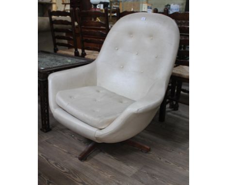 A retro cream coloured vinyl swivel chair, height 94cm, width 86cm, depth 75cm. Some signs of wear to include light scuffs to