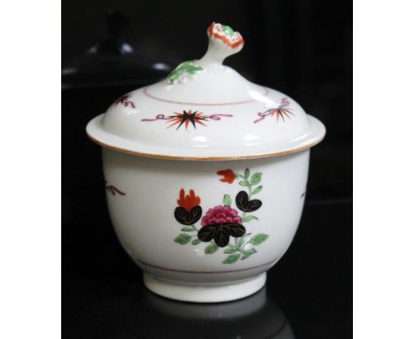 An 18th century English porcelain sucrier, probably Worcester, with floral finial, black and orange starts over purple ribbon