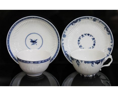 A matched pair of Worcester porcelain tea cups/bowl and saucers, circa 1760, each decorated in blue and white and both with b