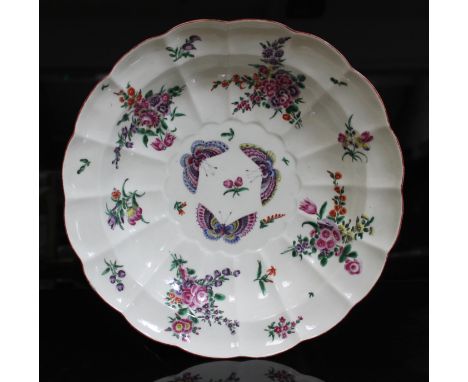 A Worcester porcelain soup plate, circa 1770, of scalloped form and decorated in over enamels with floral sprays and three ce