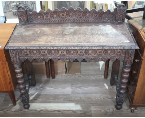 A Victorian carved oak side table, height 94cm, width 104cm and depth 43cm.  There are some marks and light scractches to tab