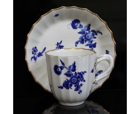 A Worcester coffee cup and saucer, circa 1760, of fluted form and decorated in over-glaze blue bouquets and gilt edges, squar