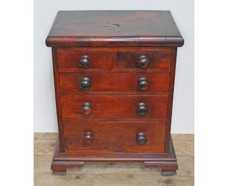 A Victorian miniature "apprentice" chest of drawers in yew wood with turned knobs and ogee bracket feet, height 46cm, width 3