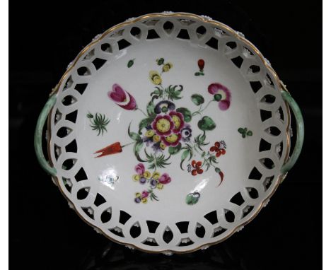 A Worcester porcelain basket, circa 1770, pierced round form with twist handles, painted bouquet to interior and moulded flow